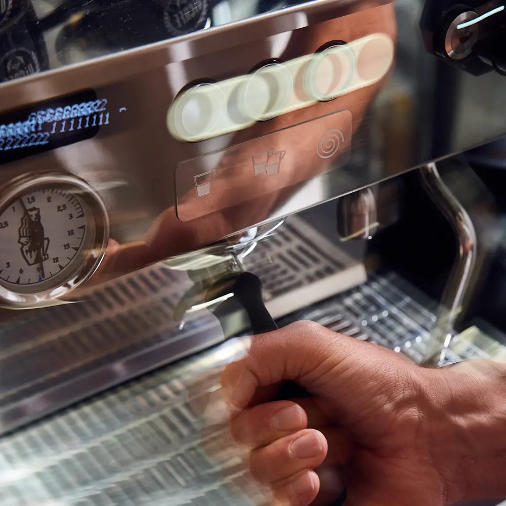 Siebträger wird in die Espressomaschine eingespannt – praktische Übung im Barista Kurs der ViCAFE Academy.
